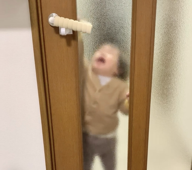 チャイルドロックでドアノブが動かせないと泣いている1歳児