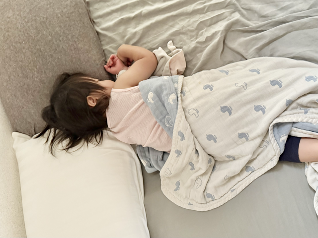 寝室のベッドで眠っている1歳児