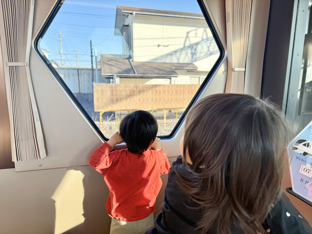 3歳児と1歳児が窓の景色に夢中になっている様子