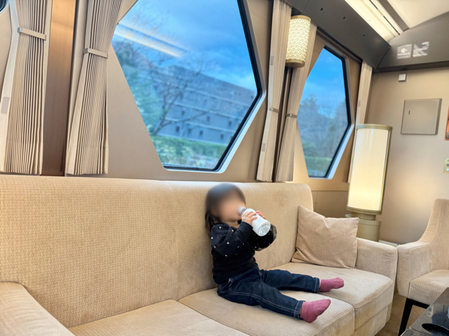 コックピットスイートのソファ席でお水を飲む1歳児